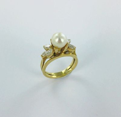 une bague en or sertie d'une perle et de diamants
