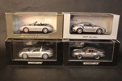 three boxed silver porsche models in boxes on a black surface