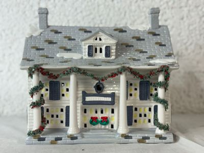 une figurine représentant une maison ornée d'une couronne sur la façade