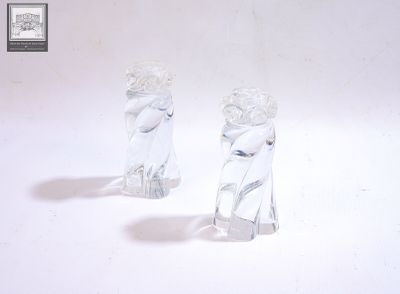deux figurines en verre posées sur une surface blanche