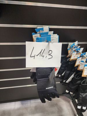 de nombreuses paires de gants suspendues à un porte-gants dans un magasin