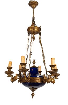 une image d'un lustre muni d'un abat-jour en verre bleu suspendu au plafond