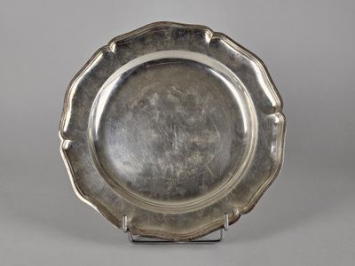 un plateau d'argent antique sur un support sur fond gris
