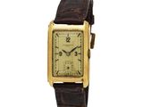 une montre-bracelet plaquée or avec un bracelet en cuir marron