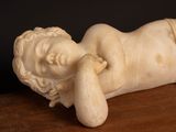 a statue of a baby laying down on a table