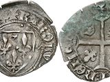 a silver coin with a cross on the front and a shield on the back