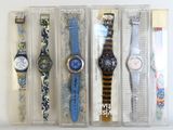 quatre montres sont présentées dans un emballage posé sur une surface blanche