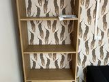 a wooden shelf with a book case and a black couch