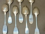 six spoons and a fork on a table