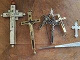 trois croix et un couteau posés sur une table en bois