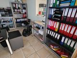 une pièce où se trouvent de nombreux classeurs et un ordinateur posé sur le bureau