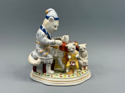 une figurine représentant une femme et deux chats posée sur une table