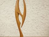 a wooden sculpture sitting on a table with a white wall in the background