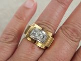 a woman ' s hand with a gold and silver ring on it
