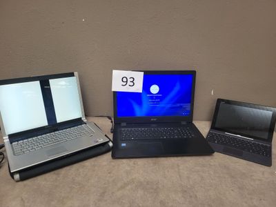 three laptops sitting on a table with a price tag on the screen
