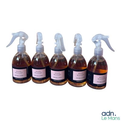 quatre flacons de liquide munis d'un vaporisateur, sur fond blanc