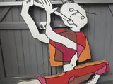 un tableau représentant un homme jouant de la flûte sur la façade d'un immeuble