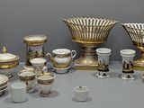 une table sur laquelle sont disposés de nombreux objets dorés et blancs