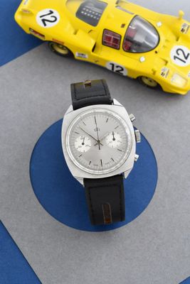 une montre posée sur une table à côté d'une petite voiture