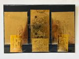 trois timbres dorés exposés sur un fond noir