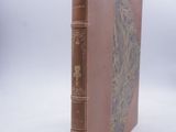 an old book sitting on top of a white surface with a white background