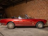 an image of a red convertible car parked in a garage