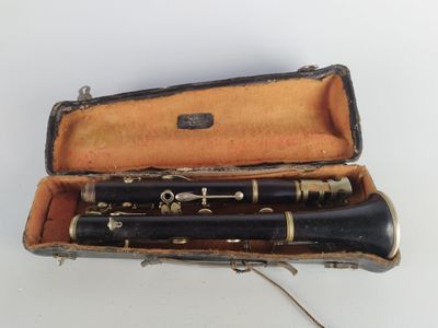 deux clarinettes dans un étui posé sur une surface blanche