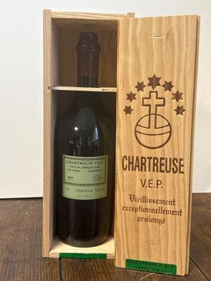 la bouteille de vin se trouve dans une caisse en bois posée sur la table