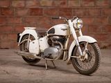 a white motorcycle that is parked in front of a brick wall
