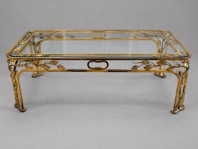 une table basse en laiton avec un plateau en verre