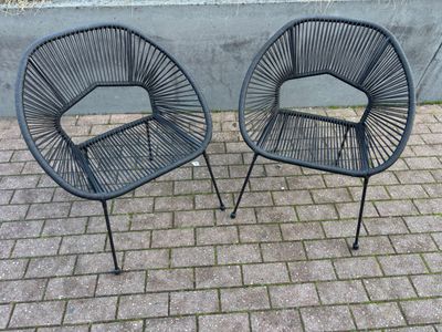 deux chaises placées l'une à côté de l'autre sur un sol en briques