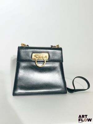 un sac à main noir muni d'un anneau doré sur la poignée