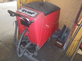 a red machine that is sitting in a garage