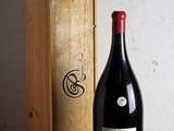 une bouteille de vin posée à côté d'une caisse en bois