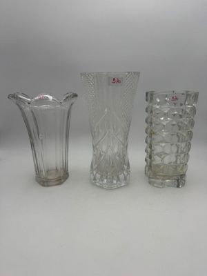 trois vases en verre sont alignés sur une surface blanche