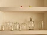 de nombreux bocaux en verre alignés sur une étagère dans une pièce