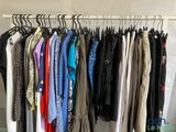 beaucoup de vêtements suspendus à une étagère dans une pièce