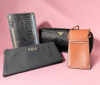 three black and brown wallets on a pink background
