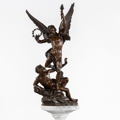 une statue en bronze représentant un ange et un homme, posée sur un socle
