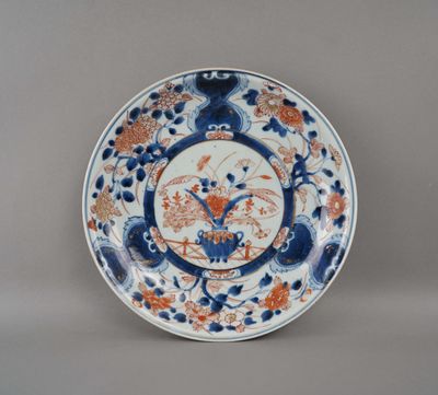 assiette bleue et blanche ornée de fleurs orange et d'oiseaux
