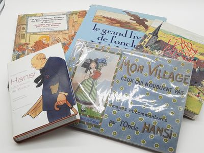 Plusieurs livres pour enfants sont posés sur une table, à côté d'une paire de ciseaux