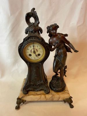 une statue représentant une femme tenant une horloge, posée sur un socle en marbre