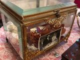 une boîte en verre posée sur une table, avec une photo à l'intérieur