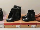 Quatre paires de bottes pour femmes sont exposées sur des boîtes