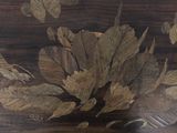 a close up of a painting of leaves on a table