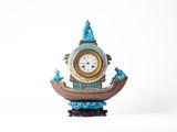 une horloge posée sur un support sur une surface blanche
