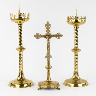 two gold candles are sitting next to each other on a white surface