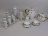 a white and gold tea set with cups and saucers