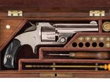 un pistolet dans un coffret en bois sur fond blanc, avec un fond blanc