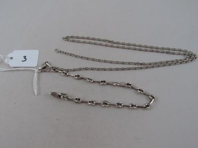 two silver chains with a tag attached to them on a table
